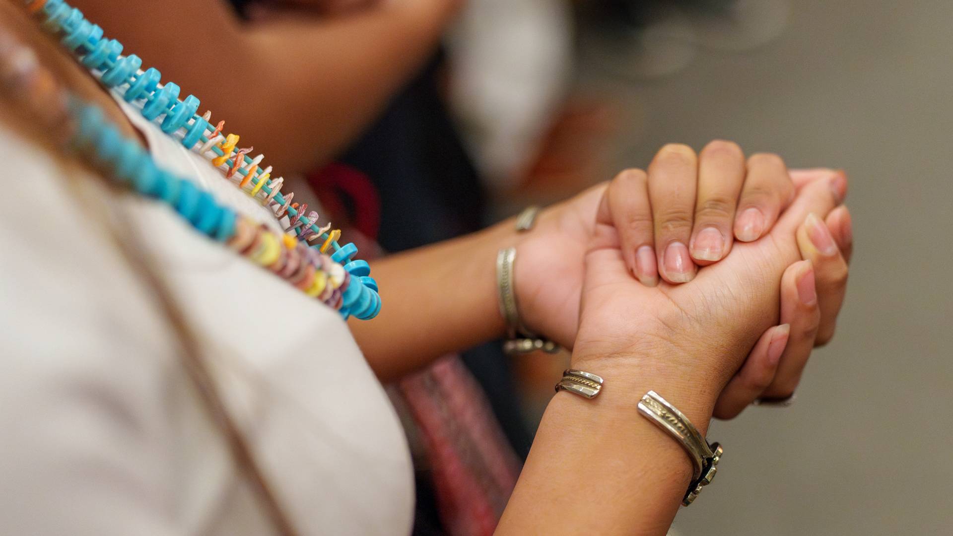 Closing the students' closed hands.