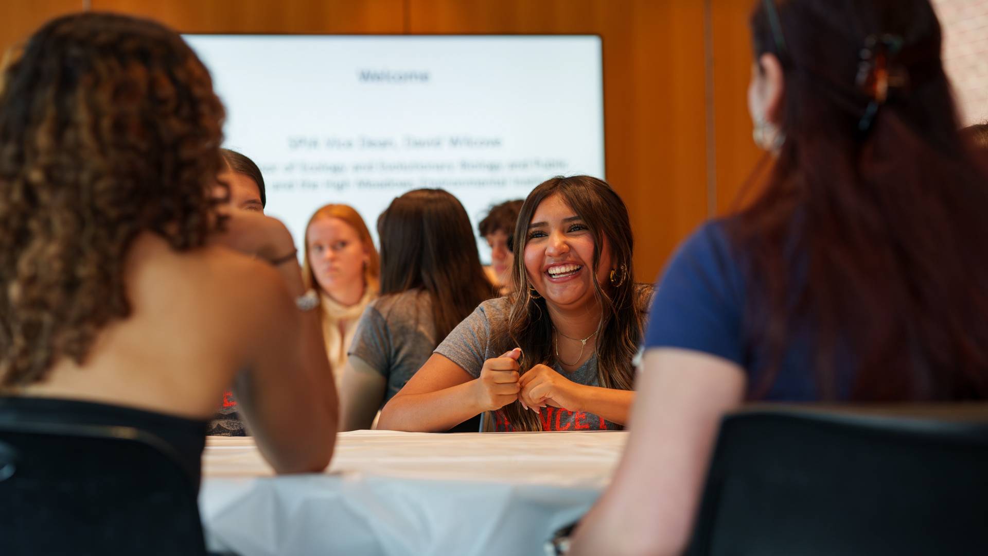 Smiling students sitting around the table